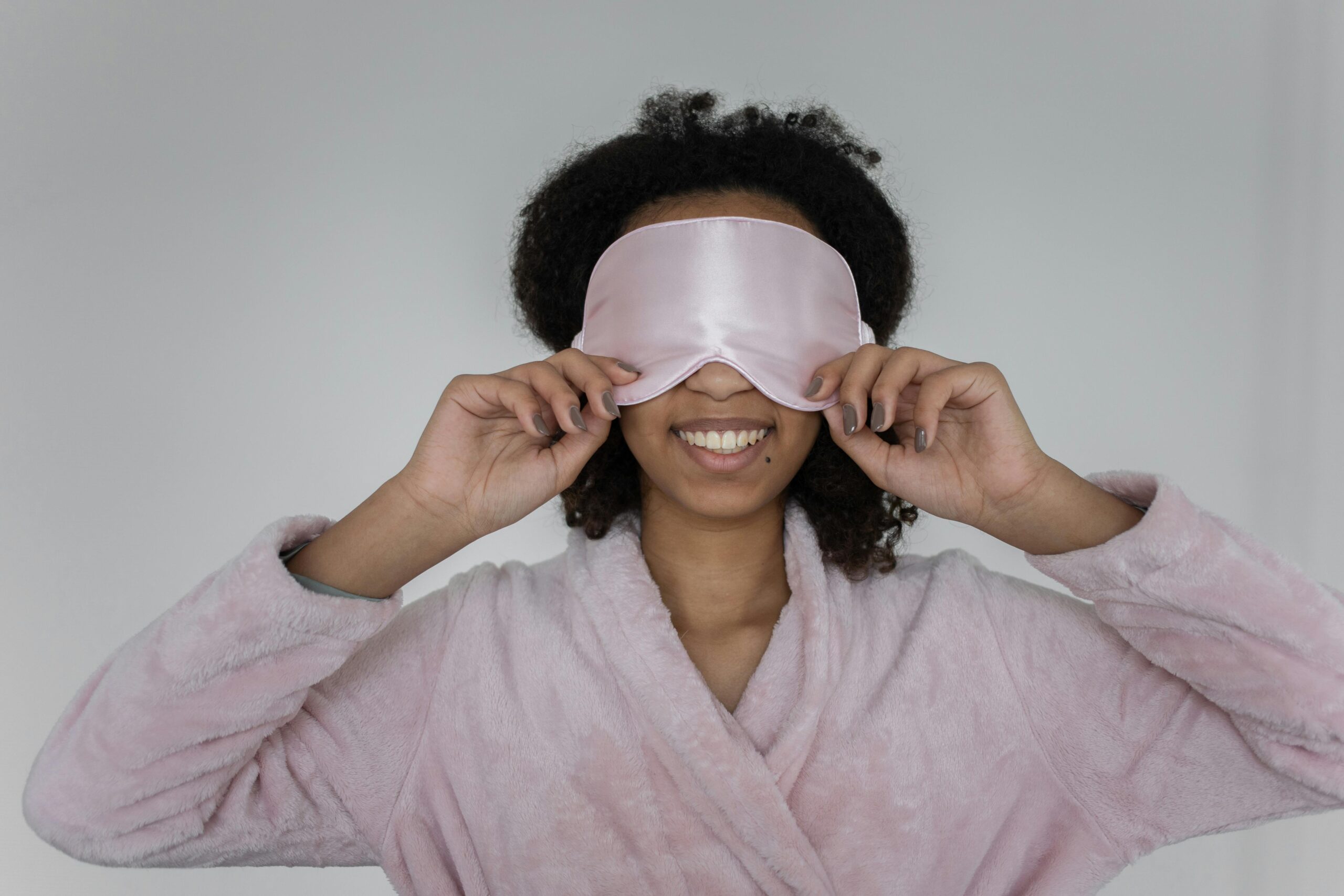 woman wearing silk sleep mask smiling