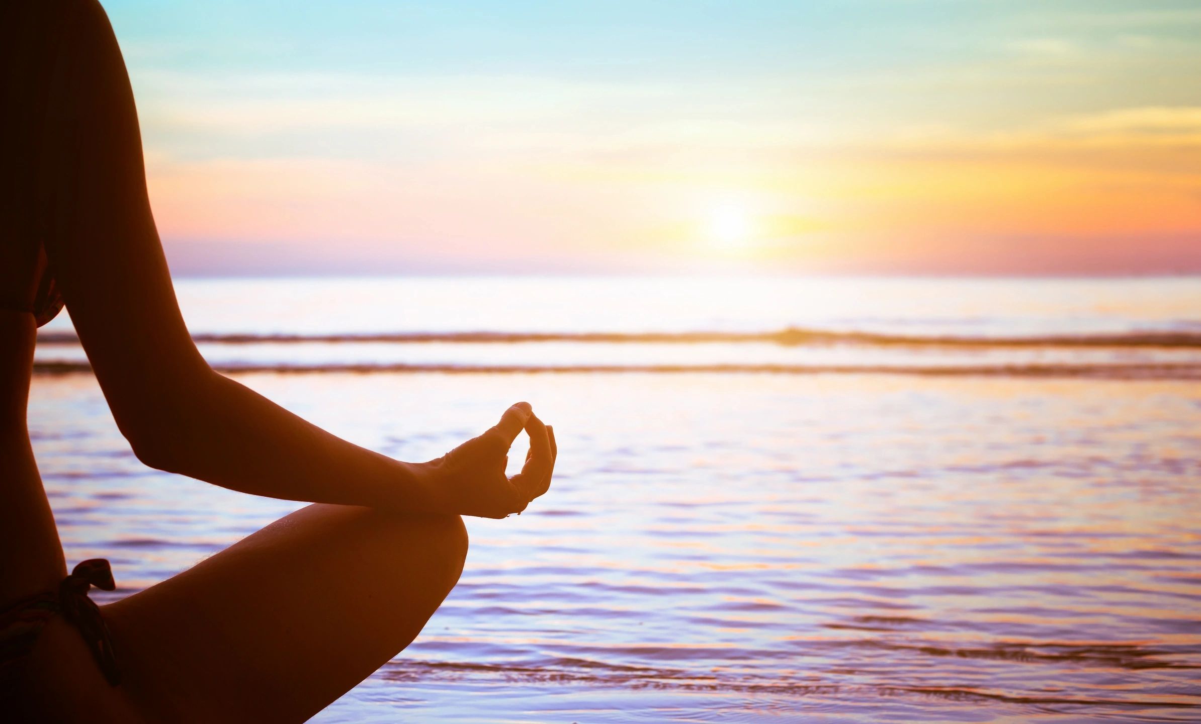 woman meditating by water